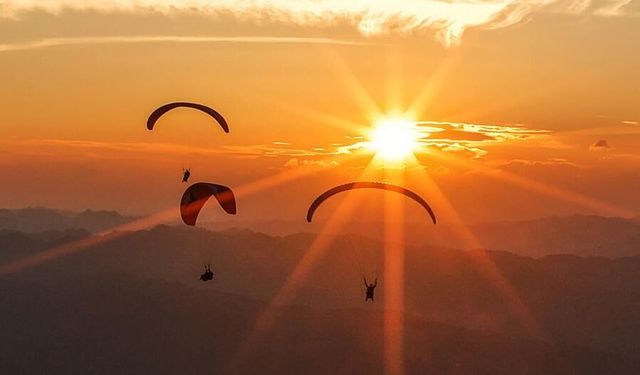 Guizhou'da ziyaretçiler dağların üzerinde yamaç paraşütü yapıyor